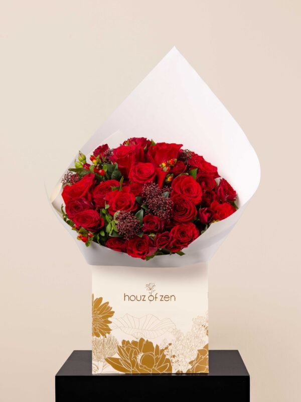 hand-tied red rose bouquet with hypericum berries and dark green leaves