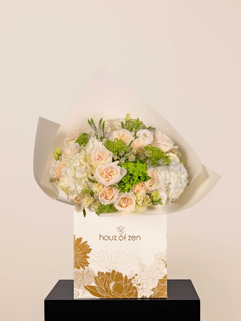 Zen Ivory Elegance bouquet featuring ivory roses, white hydrangeas, and green accents in white Houz of Zen wrap.