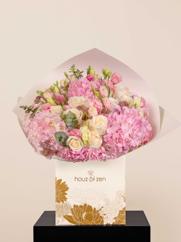 Pink hydrangea and cream rose bouquet wrapped in white paper