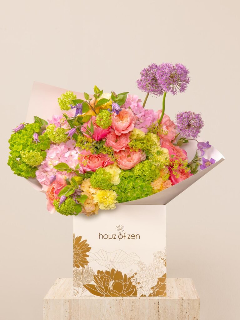 Colorful floral arrangement with roses, allium, hydrangea, and clematis Caption:
