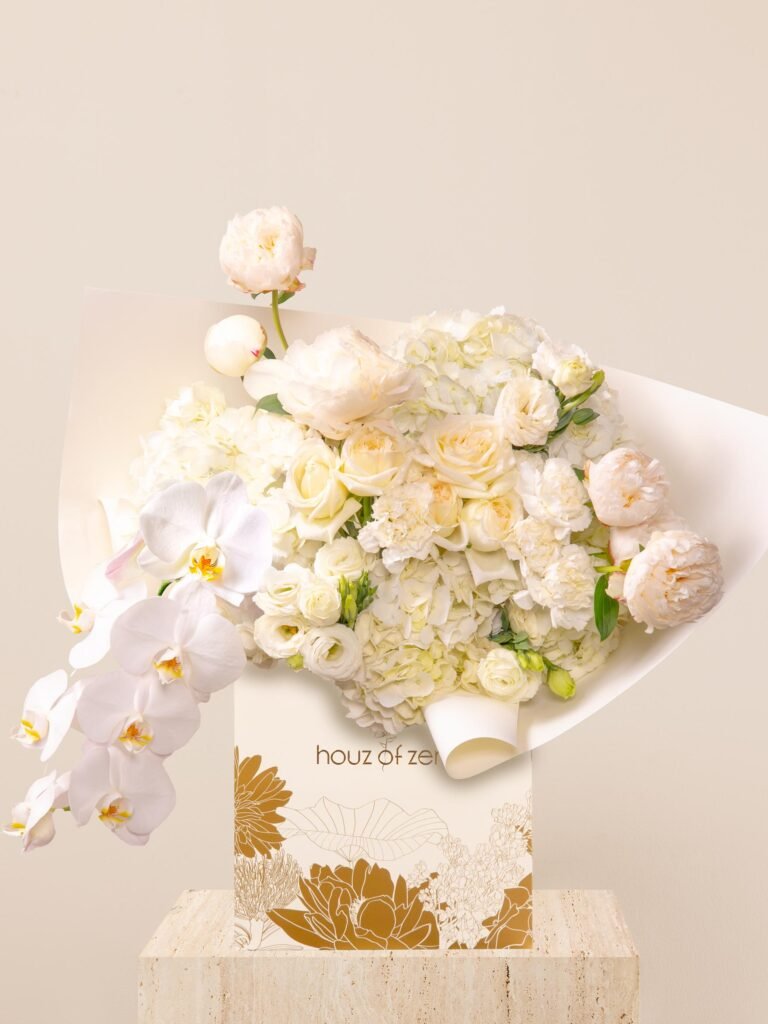 ivory white flower bouquet with peonies, orchids, hydrangeas, and lisianthus in white wrap