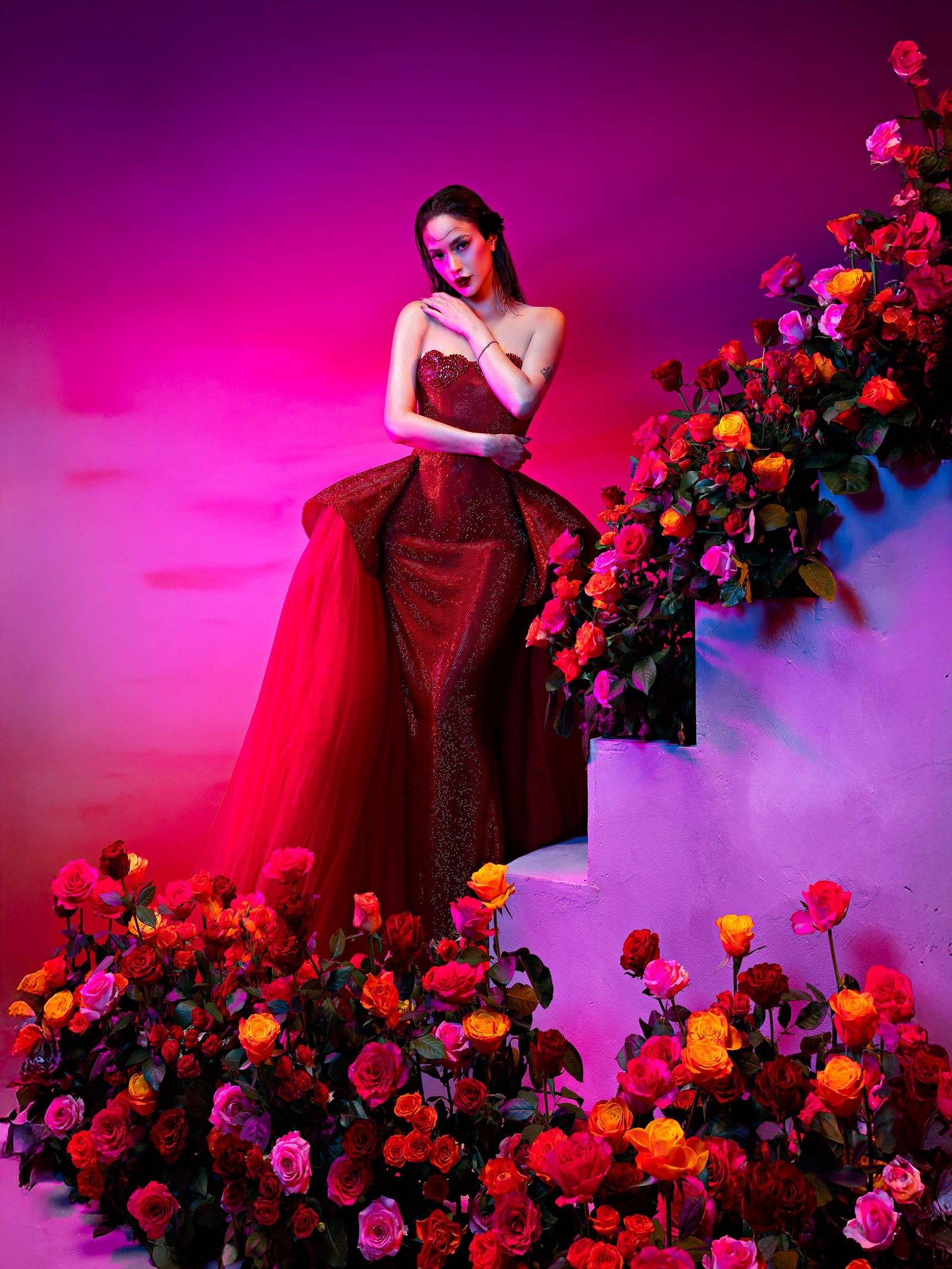 Arci Muñoz in a red couture gown standing beside cascading roses and sculpted stairs, styled by Houz of Zen