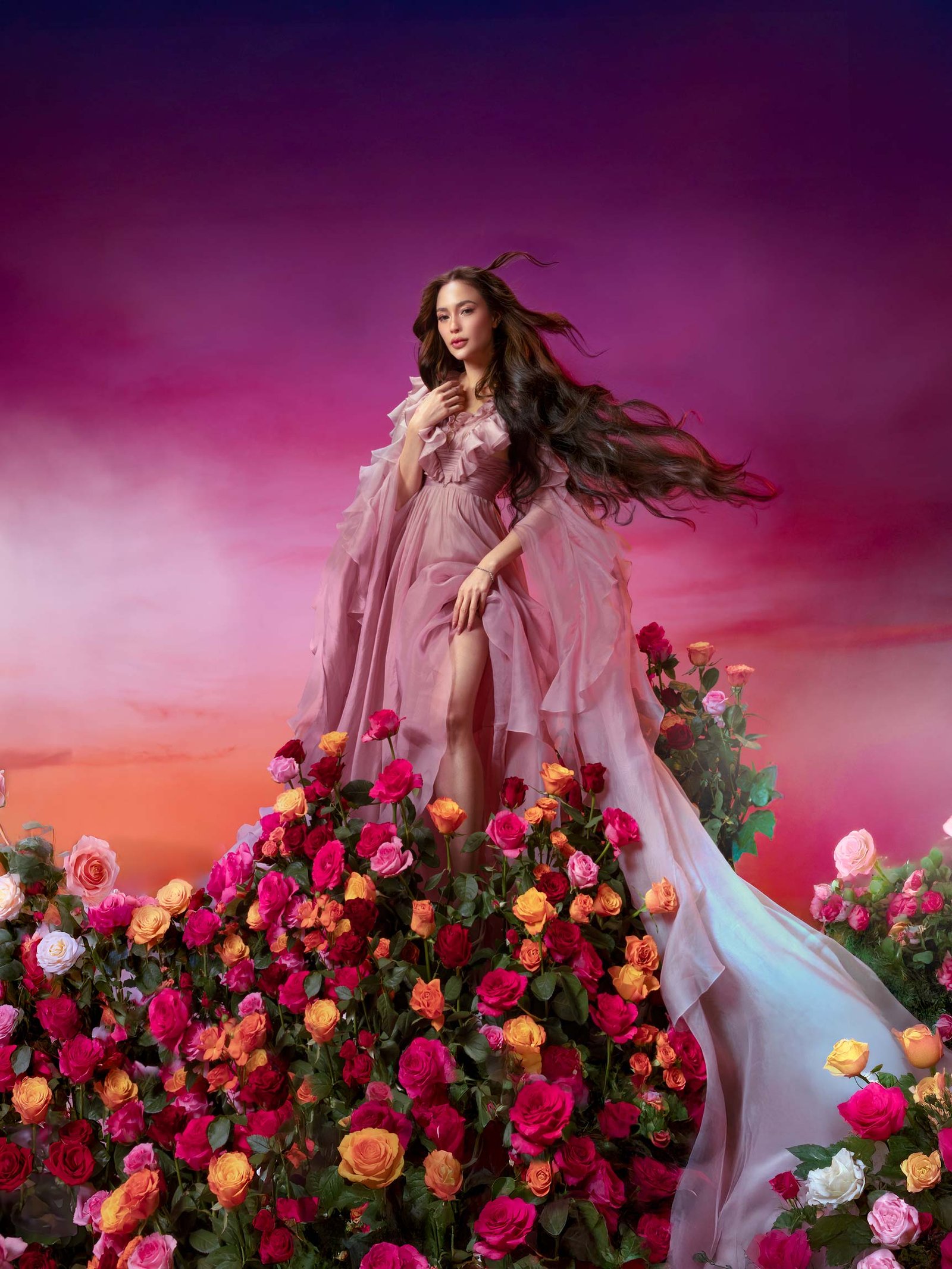 Arci Muñoz in a flowing mauve gown surrounded by vibrant roses styled by Houz of Zen against a sunset-inspired backdrop
