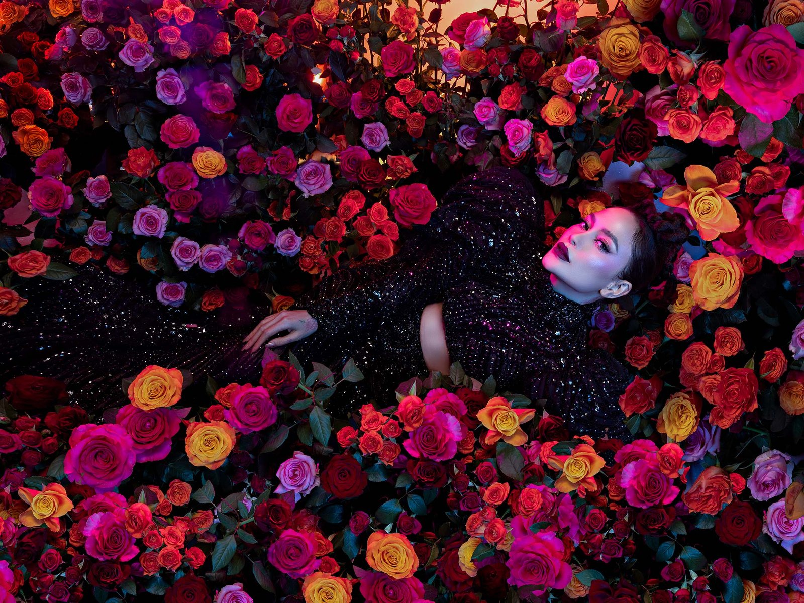 Arci Muñoz in a black sequined gown lying among vivid roses styled by Houz of Zen for a dark romantic editorial