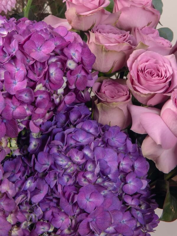 Close-up of luxury flower basket in Dubai with pink chrysanthemum pingpong and purple hydrangeas.