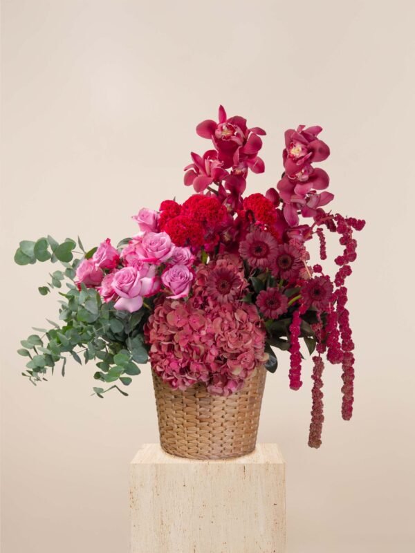 Red flower basket Dubai with cymbidium orchids, roses, hydrangeas, celosia, and amaranthus.