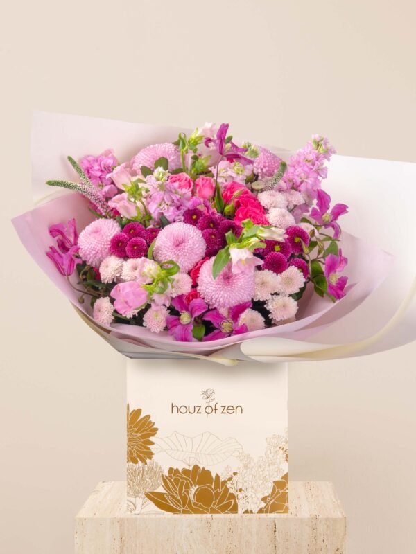 Pink flower bouquet with chrysanthemums, roses, and clematis in wrapping.