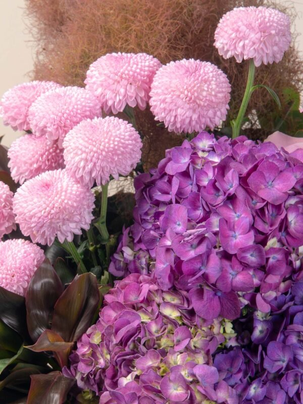 Close-up of pink chrysanthemums and purple hydrangeas in the Violet Flower Box.