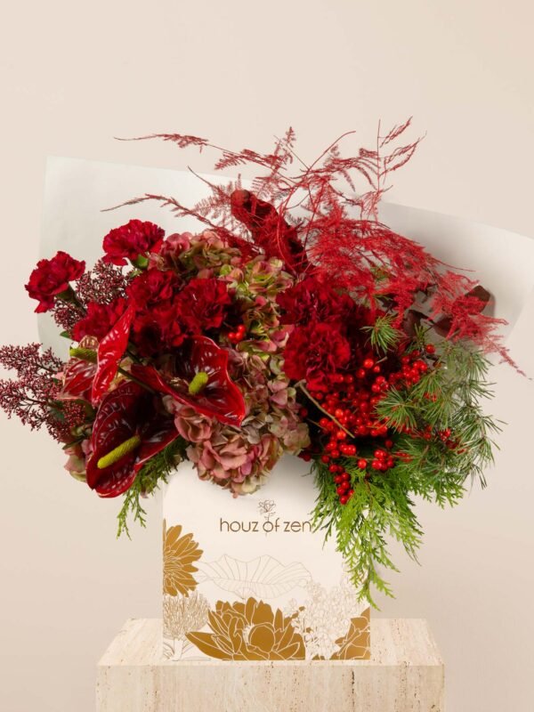 Red festive flower bouquet with hydrangeas, anthuriums, carnations, berries, and winter foliage arranged in a Houz of Zen box.